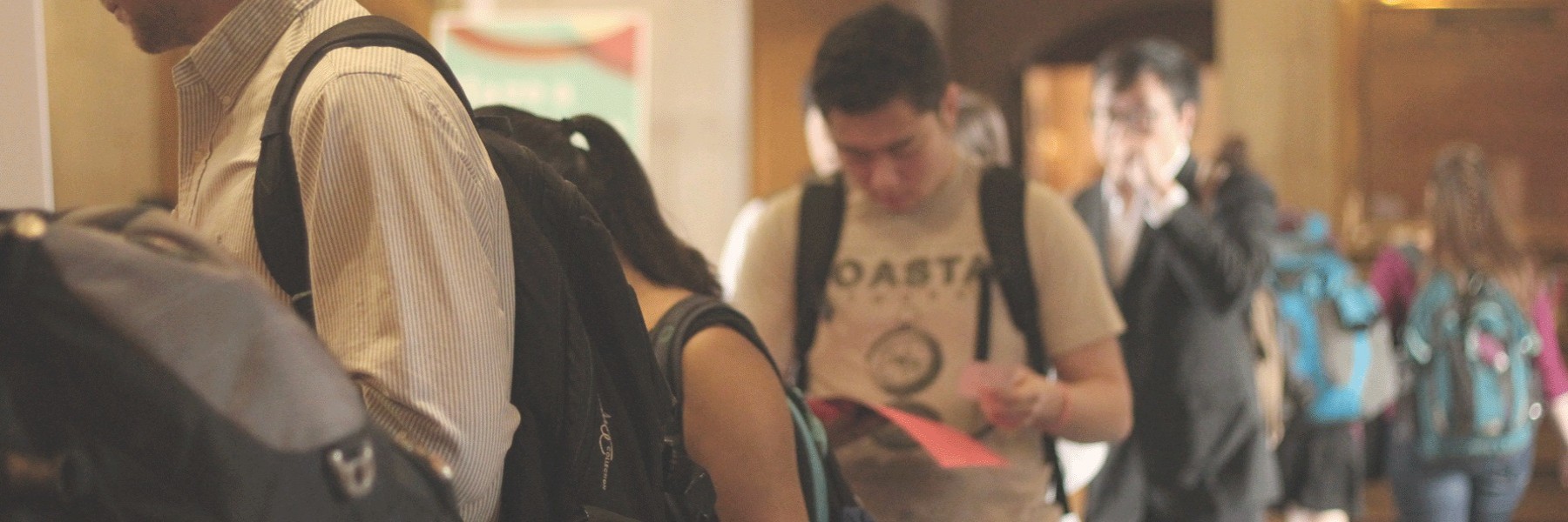 People waiting in line while reading handouts